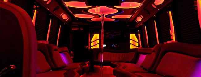 Party bus interior with red LED lighting and leather seating